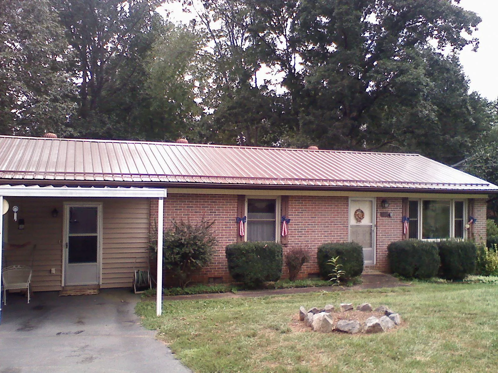 Bronze metal roof and carport on a brick ranch home — Roof Repair work by our crew in Mantee